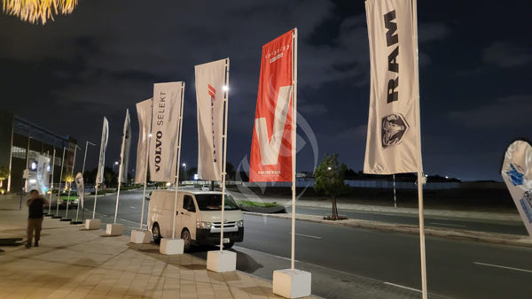 Promotional flags with brand logos on a street at night