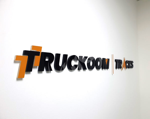Truckoom Tracks logo on a white wall