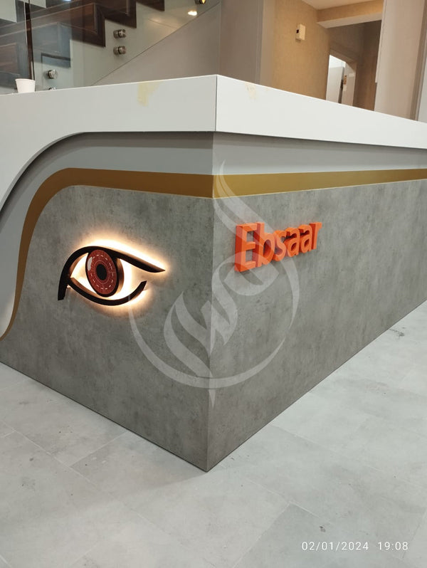 Reception desk with eye design and 'Ebsaar' logo in a modern interior setting