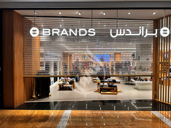 Interior of a high-end store with '8 Brands' sign on glass wall.